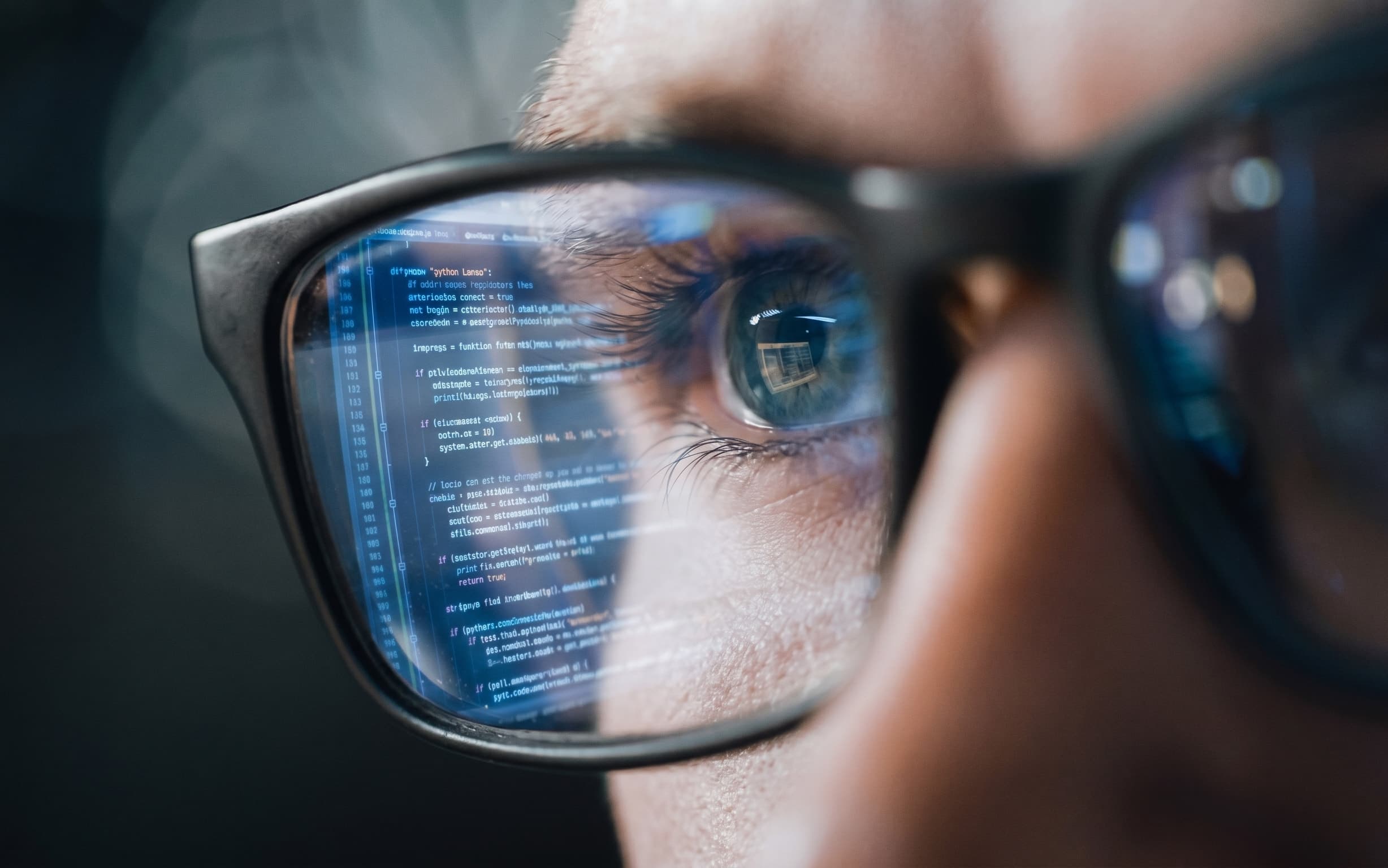 Sguardo di un tecnico con codice riflesso nelle lenti degli occhiali